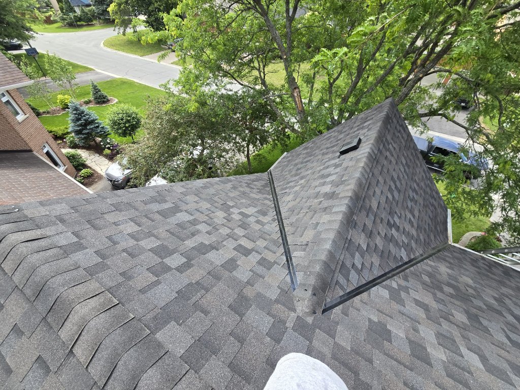 Completed architectural shingle roof with valley flashing and roof vent detail beneath mature trees by 905 Roofing Inc. in Durham Region and the GTA